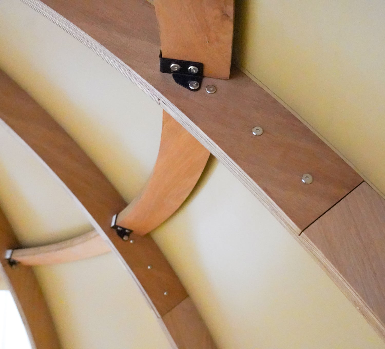 "Interior view of a geodesic dome structure showcasing wooden beams and metal fastenings, ideal for glamping solutions such as geo-domes and dome homes. Perfect for those interested in luxury Airbnb setups, sustainable living, or creating a backyard dome office. Keywords: geodesic dome house kit, artemis pod, glamping pods for sale."