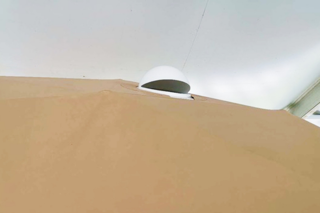 Alt text: "Close-up view of a geodesic dome tent with a porthole window, showcasing the durable fabric and modern design. Ideal for glamping, sustainable living, or creating a unique backyard space. Keywords: geodesic dome, porthole window, glamping pod."