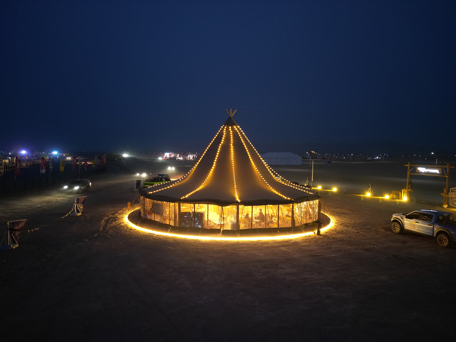 A beautifully illuminated large tent at night, showcasing a premium glamping solution with a stylish design. Ideal for those interested in luxury outdoor accommodations like geodesic domes, dome homes, and glamping pods.