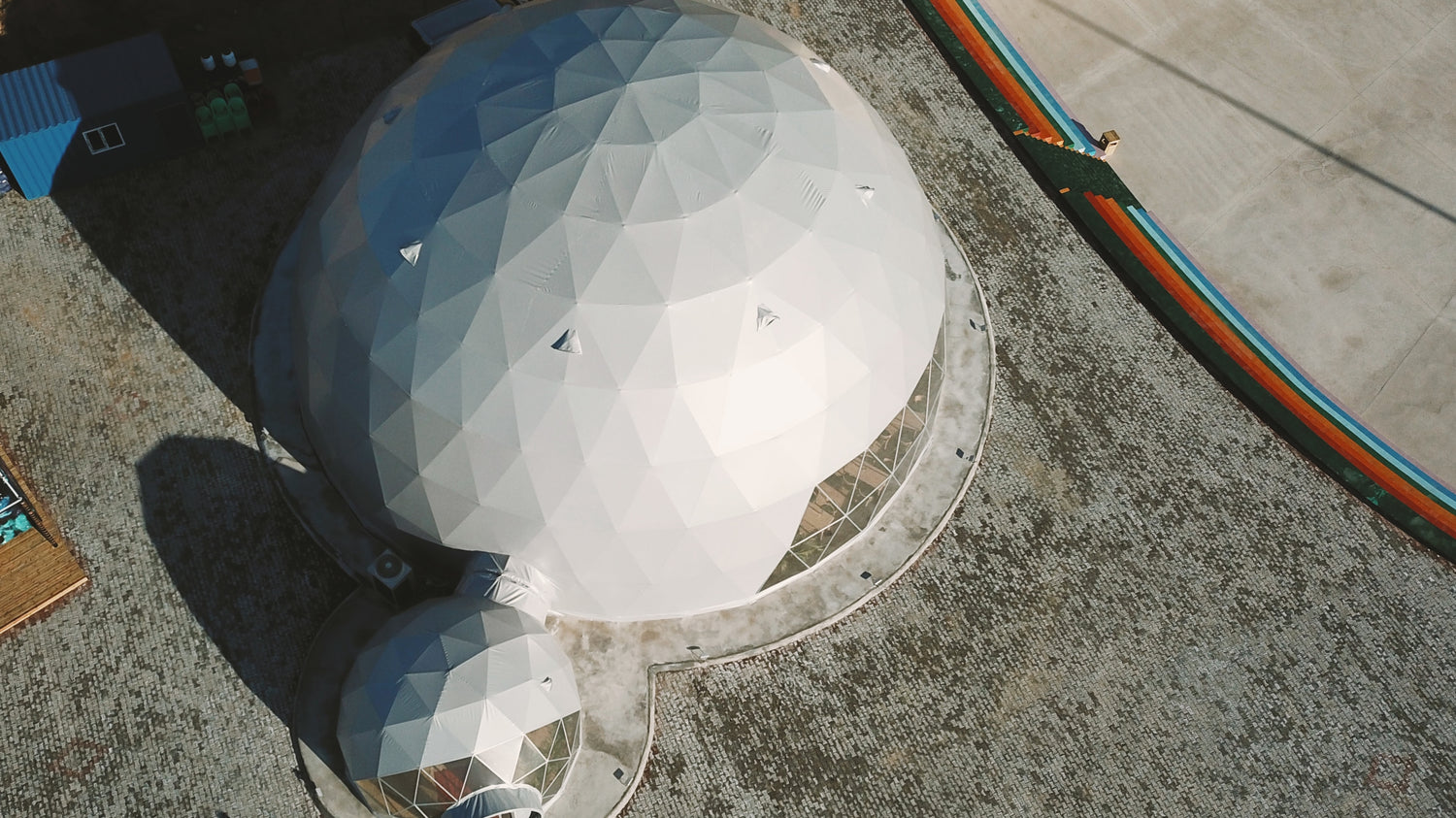 Aerial view of a large geodesic dome structure with a smaller attached dome, showcasing the company&