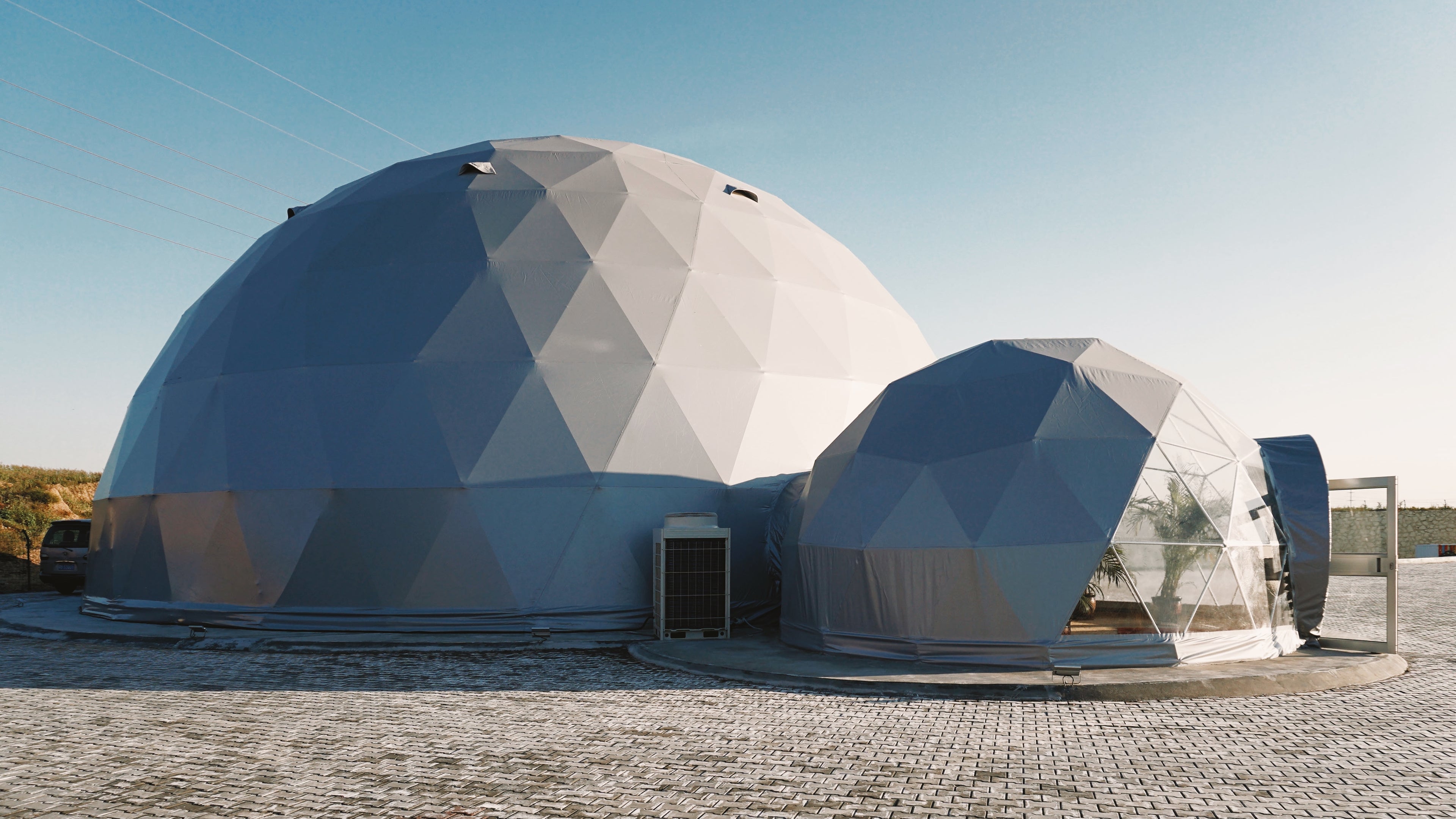 Alt text: &quot;Large geodesic dome structures with porthole windows, ideal for glamping or sustainable living. These stylish and cost-effective domes are perfect for creating a luxury Airbnb, backyard office, or art studio. Explore our range of geodesic dome house kits and glamping pods for sale.&quot;